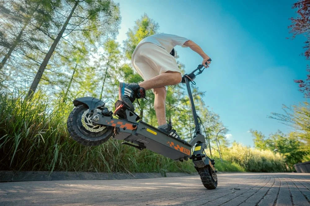 Conductor saltando un bordillo con un patinete KuKirin negro y naranja – KuKirin G2 Pro vs G4 vs G2 Master