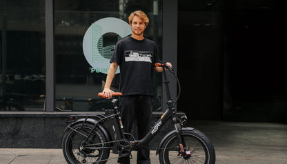OneSport OT16 Max Electric bike black with a guy standing and holding the electric bike