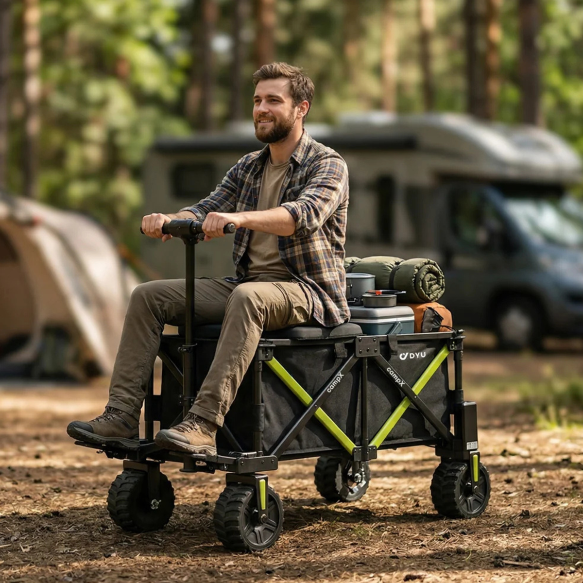 Un hombre sentado en el DYU CampX con equipaje en un camping en el bosque, autocaravana y tienda al fondo