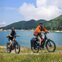 Dos personas con la bicicleta eléctrica fat bike ENGWE E26 3.0 PRO junto al mar