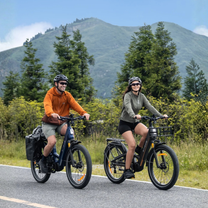 Dos personas con la bicicleta eléctrica fat bike ENGWE E26 3.0 PRO por la carretera en la montaña