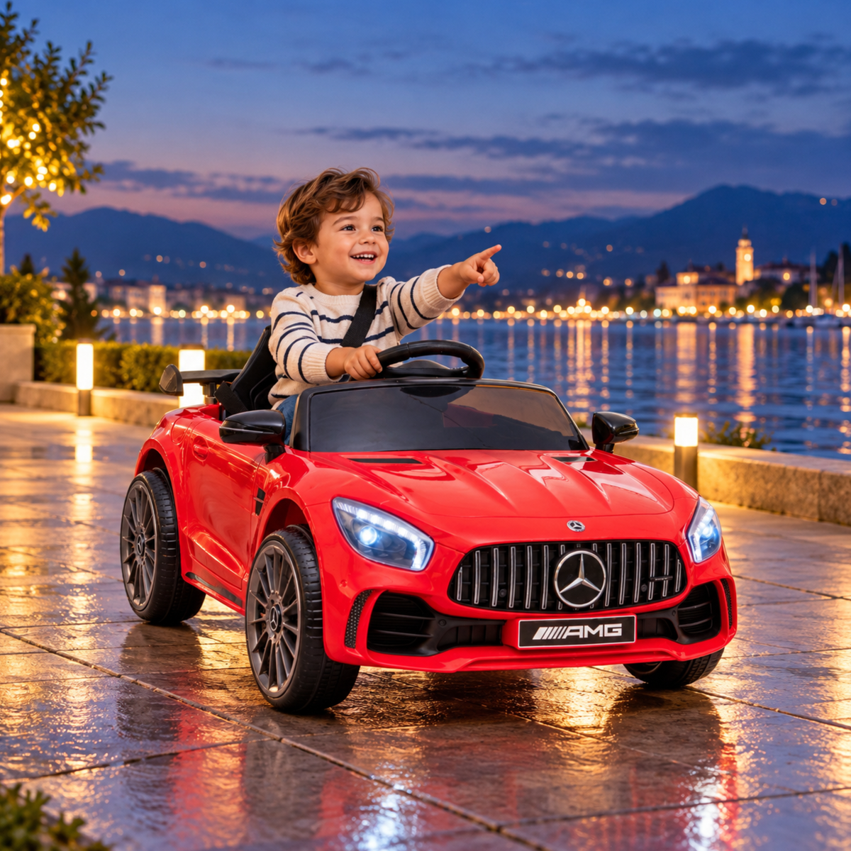 Niño conduciendo el coche eléctrico para niños Mercedes AMG GT junto al mar