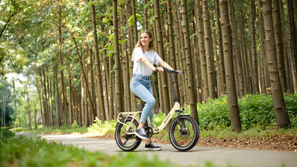 Mujer sonriente de pie con la OneSport OT16 Pro color crema en un sendero del bosque entre troncos altos