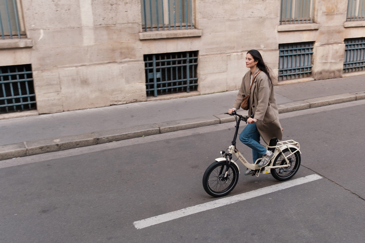 OneSport OT16 Pro: mujer montando en bicicleta por una calle, vista lateral desde arriba