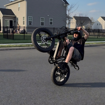 Hombre montando la bicicleta eléctrica fat bike TST R002 Plus en color negro por una calle