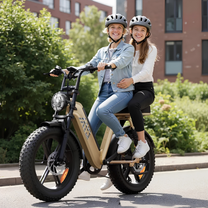 Mujer montando la bicicleta eléctrica fat bike TST R7 en color beige con asiento de pasajero por la ciudad
