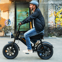 Hombre montando la bicicleta eléctrica fat bike URLIFE T16 en color negro con casco por la ciudad