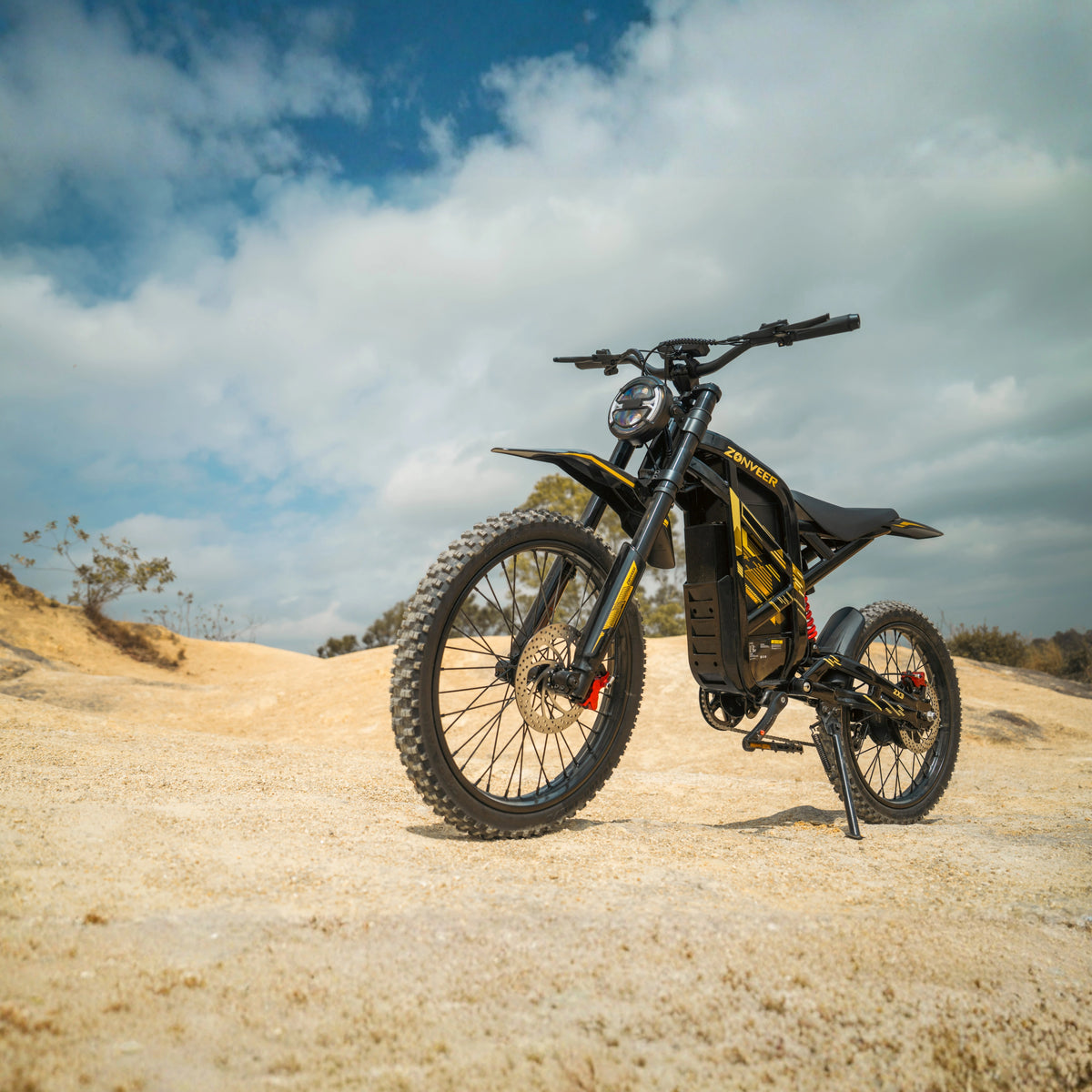 Bicicleta eléctrica ZONVEER ZX3 en vista frontal en ángulo sobre terreno arenoso