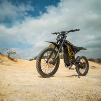 Bicicleta eléctrica ZONVEER ZX3 en vista frontal en ángulo sobre terreno arenoso