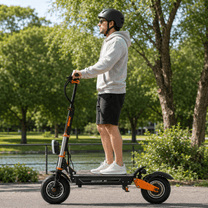 Hombre de pie junto al patinete eléctrico BOYUEDA M2 en un parque