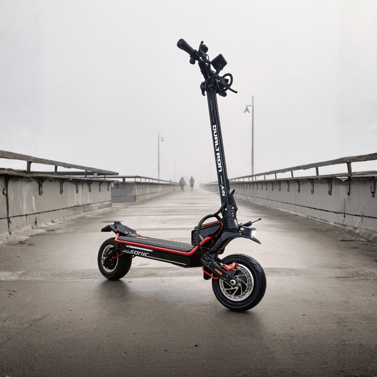 Patinete eléctrico DUALTRON Alien en vista frontal en ángulo sobre un puente
