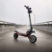 Patinete eléctrico DUALTRON Alien en vista frontal en ángulo sobre un puente