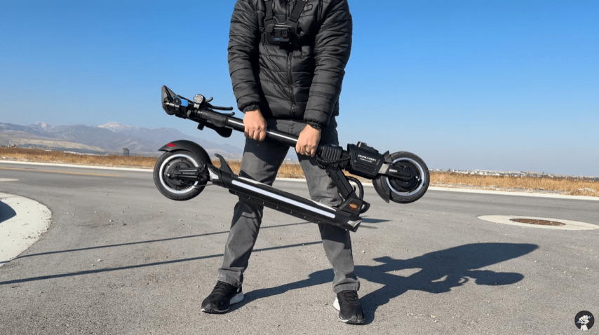 Persona llevando el patinete eléctrico DUALTRON POPULAR plegado