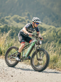 Hombre montando la bicicleta eléctrica fat bike Duotts E26 por un camino peatonal