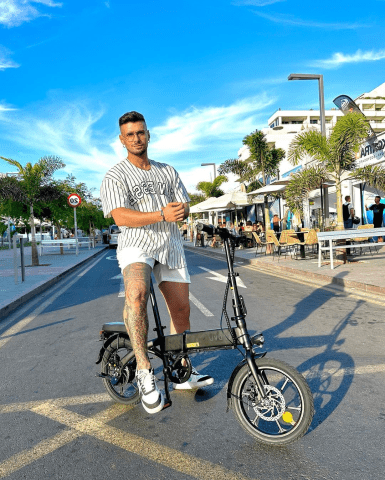 Hombre de pie junto a la bicicleta eléctrica plegable DYU A1F Pro en la ciudad