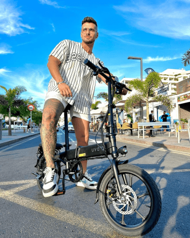 Hombre de pie junto a la bicicleta eléctrica plegable DYU A1F Pro en la ciudad