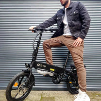 Hombre de pie junto a la bicicleta eléctrica plegable DYU A1F Pro