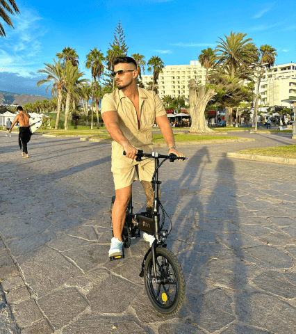 Hombre de pie junto a la bicicleta eléctrica plegable DYU A1F Pro en la ciudad