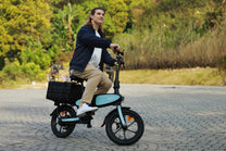 Hombre montando la bicicleta eléctrica plegable DYU C2 por un camino peatonal