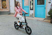 Mujer montando la bicicleta eléctrica plegable DYU C2 por la ciudad