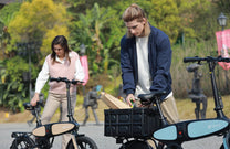Dos personas con la bicicleta eléctrica plegable DYU C2 por la ciudad