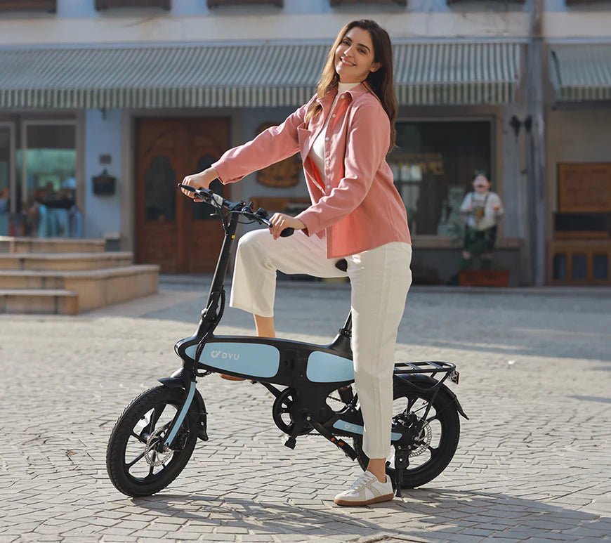 Mujer de pie junto a la bicicleta eléctrica plegable DYU C2 en la ciudad