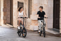Dos personas con la bicicleta eléctrica plegable DYU T1 por la ciudad
