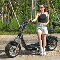 Mujer de pie junto al patinete eléctrico eHoodax X10 City Road