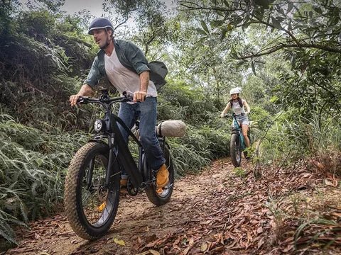 Dos personas con la bicicleta eléctrica fat bike ENGWE E26 en el bosque
