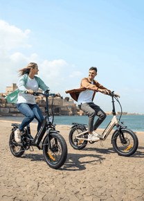 Dos personas con la bicicleta eléctrica plegable ENGWE L20 3.0 Boost junto al mar