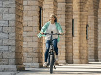 Mujer montando la bicicleta eléctrica plegable ENGWE L20 3.0 Boost por la ciudad