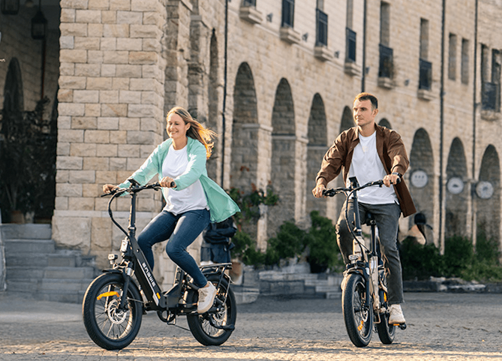 Dos personas con la bicicleta eléctrica plegable ENGWE L20 3.0 Boost por la ciudad