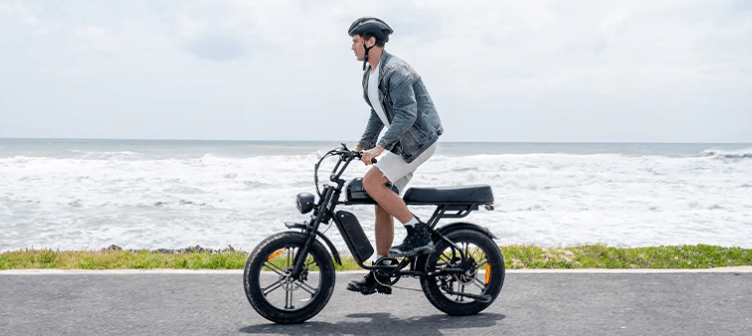 Hombre montando la bicicleta eléctrica fat bike ENGWE M1 junto al mar