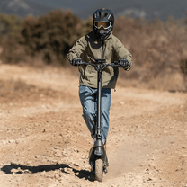 Persona montando el patinete eléctrico ENGWE Y700 por un camino de grava