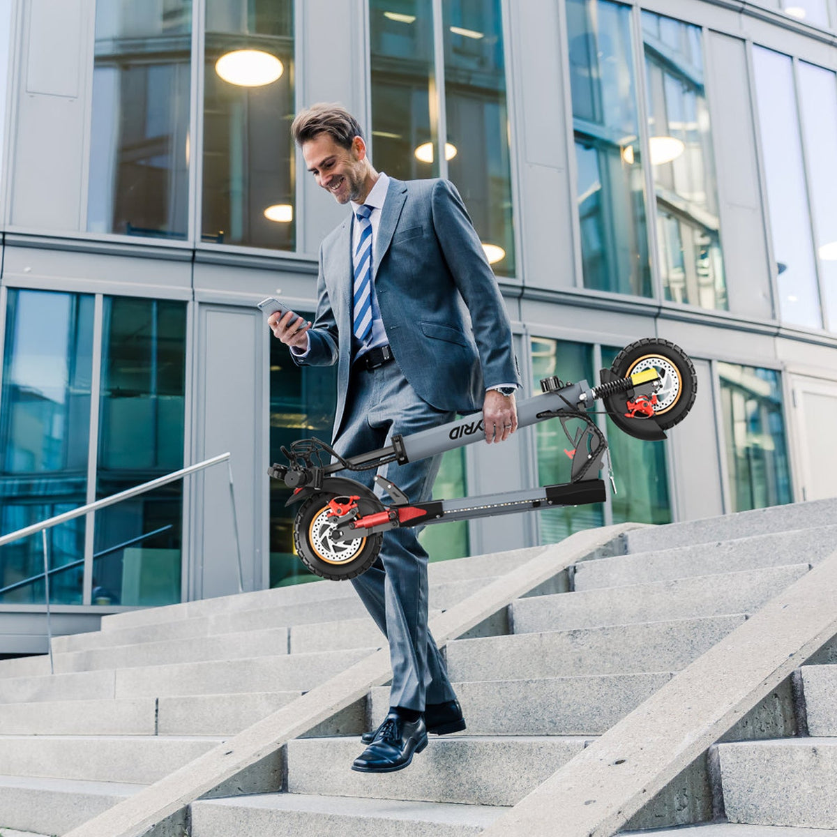 Persona llevando el patinete eléctrico iENYRID A1 plegado por la ciudad