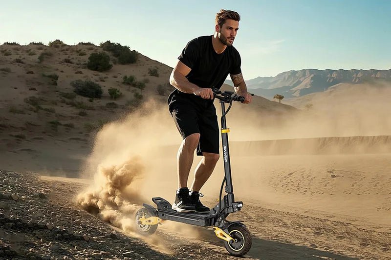 Hombre montando el patinete eléctrico iENYRID ES1 sobre terreno arenoso