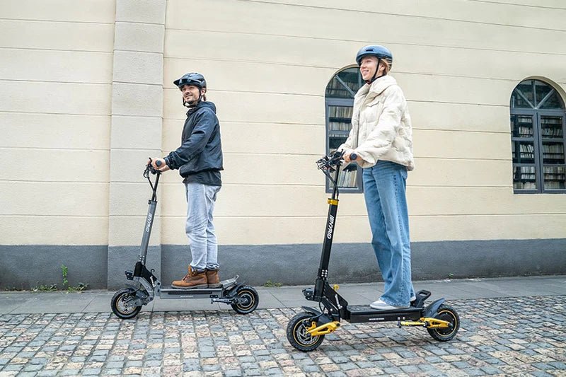 Dos personas con el patinete eléctrico iENYRID ES1 por una calle
