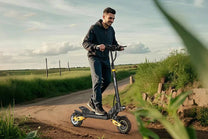 Hombre montando el patinete eléctrico iENYRID ES1 sobre el césped