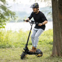 Hombre montando el patinete eléctrico iENYRID ES1 junto a un lago