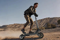 Hombre montando el patinete eléctrico iENYRID S1 en el desierto
