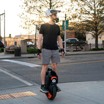 Hombre montando el monociclo eléctrico InMotion V11Y por la ciudad