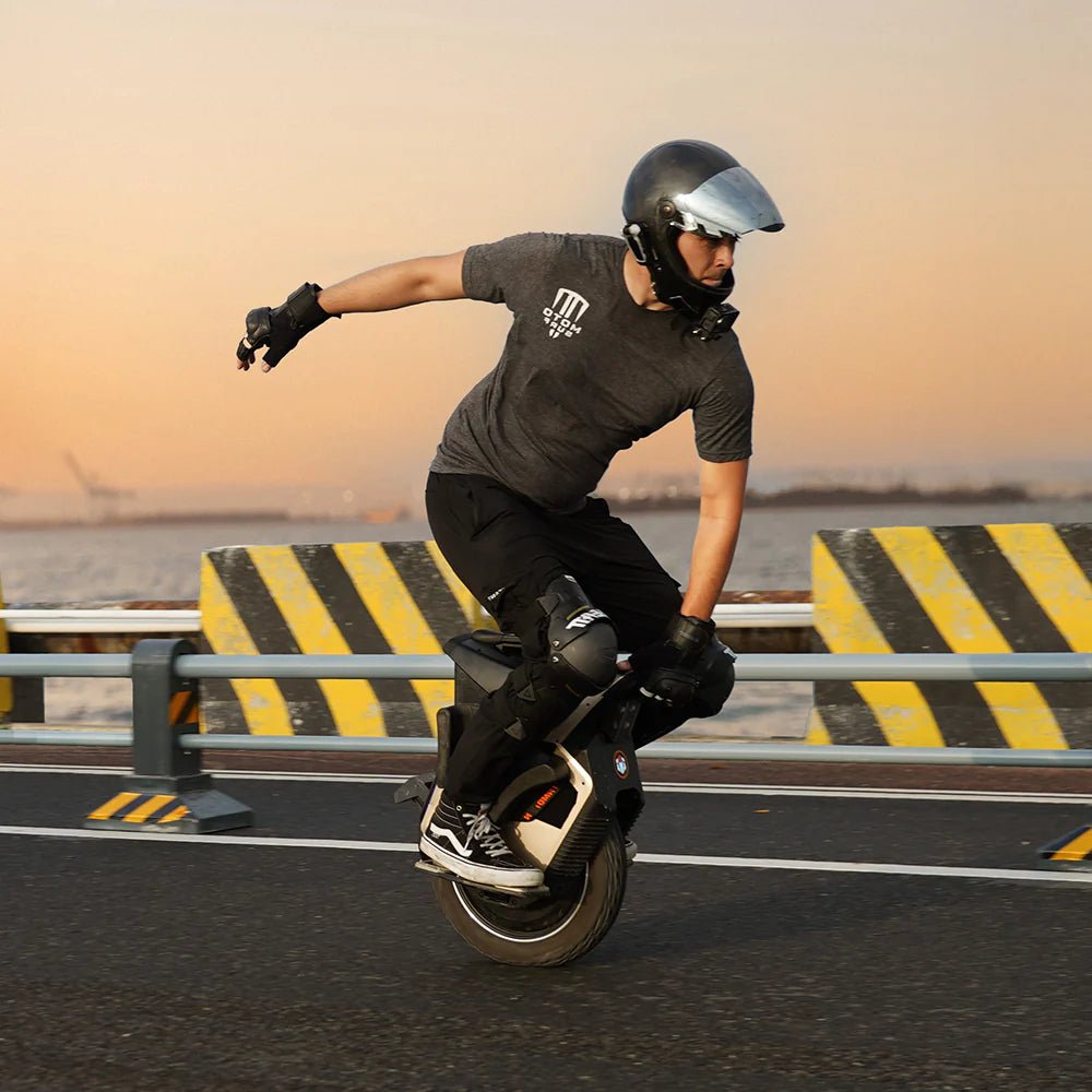 Hombre montando el monociclo eléctrico InMotion V12S al atardecer