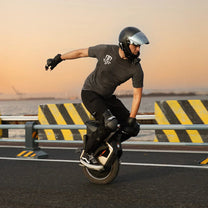 Hombre montando el monociclo eléctrico InMotion V12S al atardecer