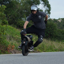 Hombre montando el monociclo eléctrico InMotion V12S por la carretera