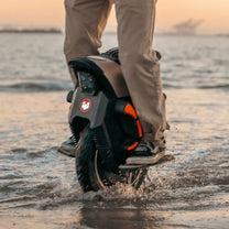 Persona montando el monociclo eléctrico InMotion V12S junto al mar