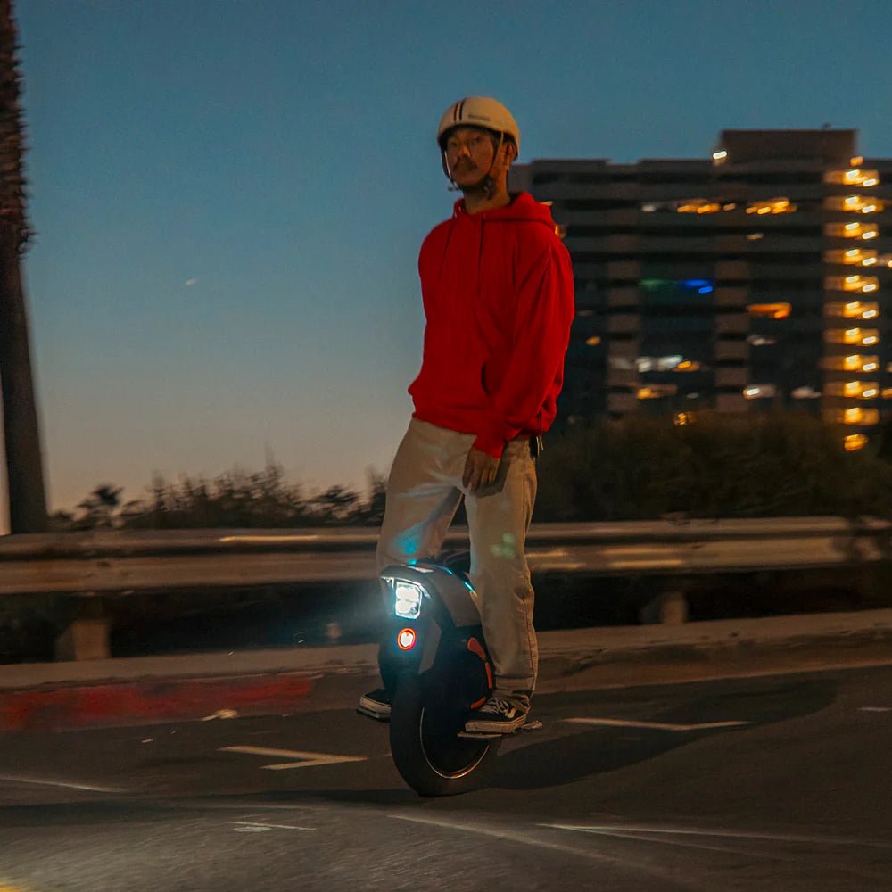 Hombre montando el monociclo eléctrico InMotion V12S al atardecer