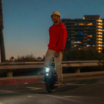 Hombre montando el monociclo eléctrico InMotion V12S al atardecer