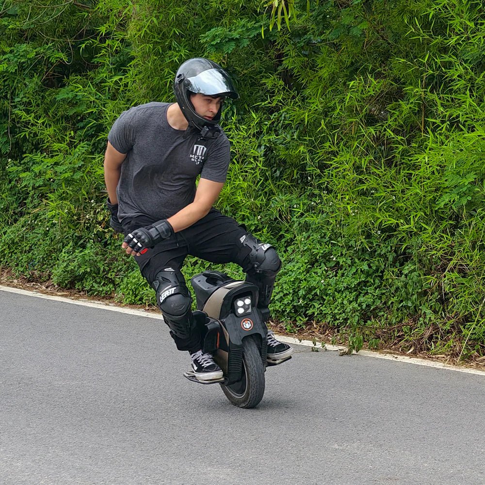 Hombre montando el monociclo eléctrico InMotion V12S por la carretera