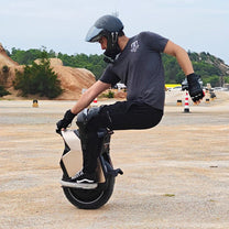 Hombre montando el monociclo eléctrico InMotion V12S sobre terreno arenoso