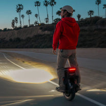 Hombre montando el monociclo eléctrico InMotion V12S en un ambiente nocturno